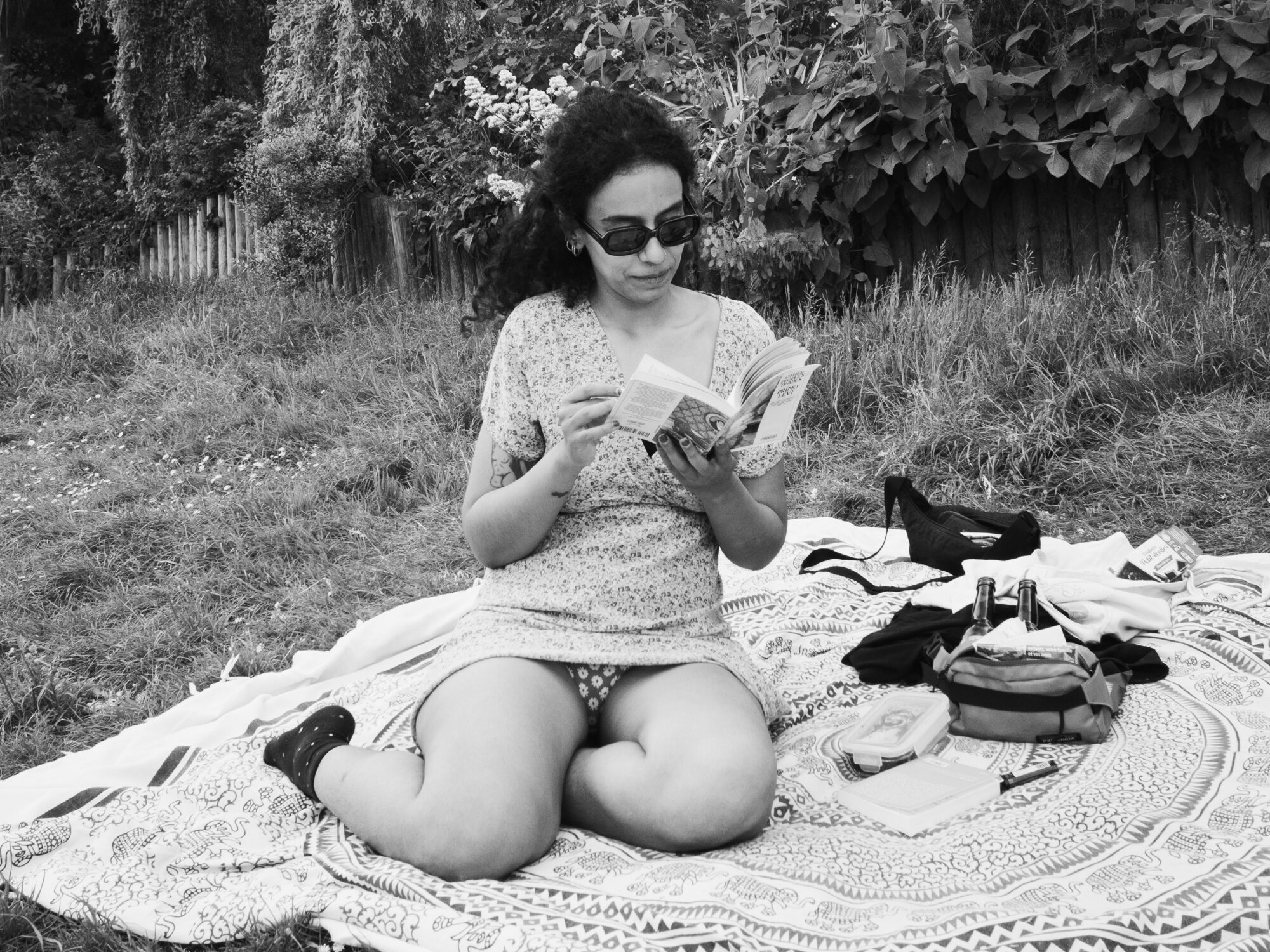 Girl sitting on a picnic rug reading a book