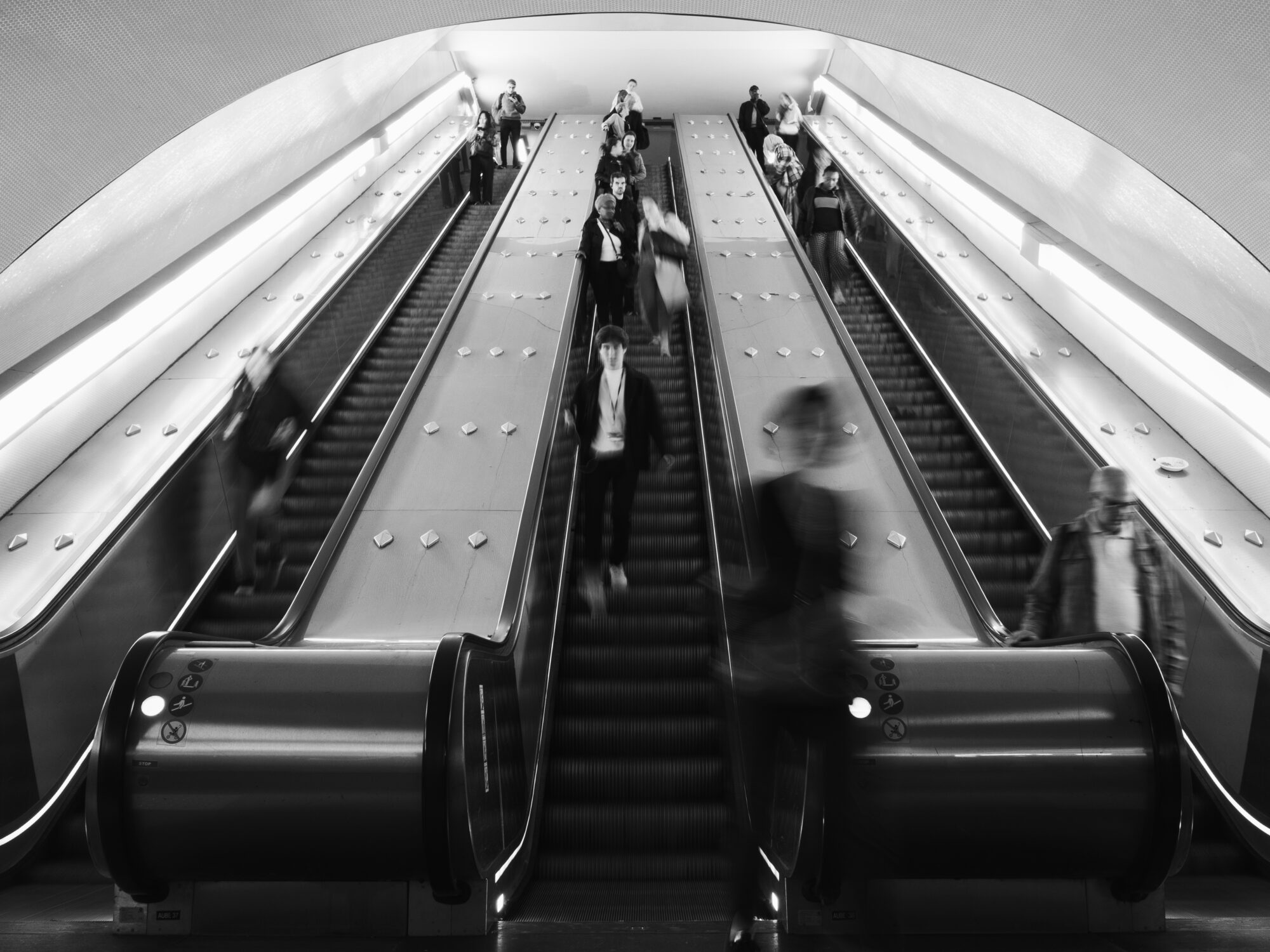 Escalators in the Paris metro with people blurred out