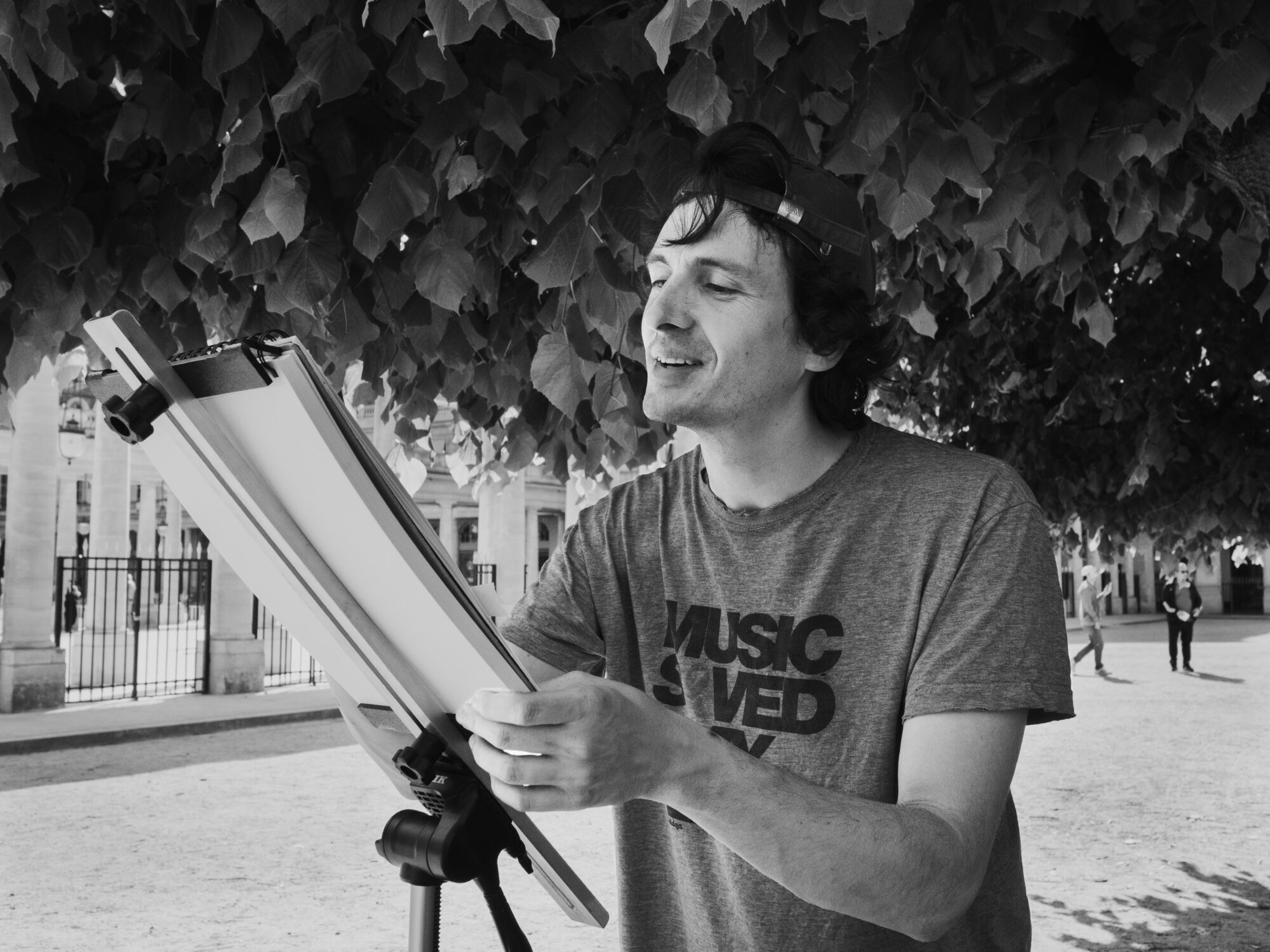 Young French man painting in a garden