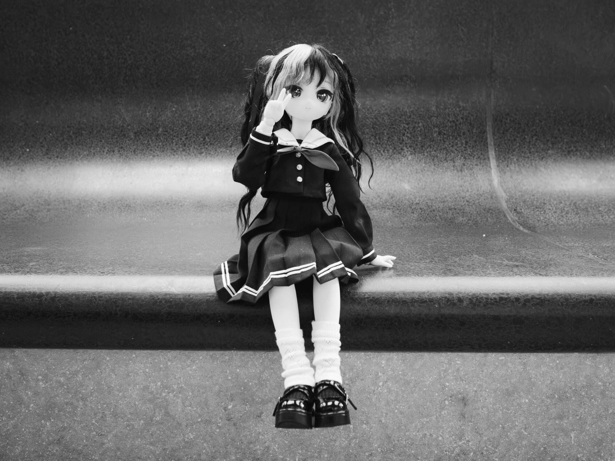 Doll in a sailor suit seated on the edge of a bench